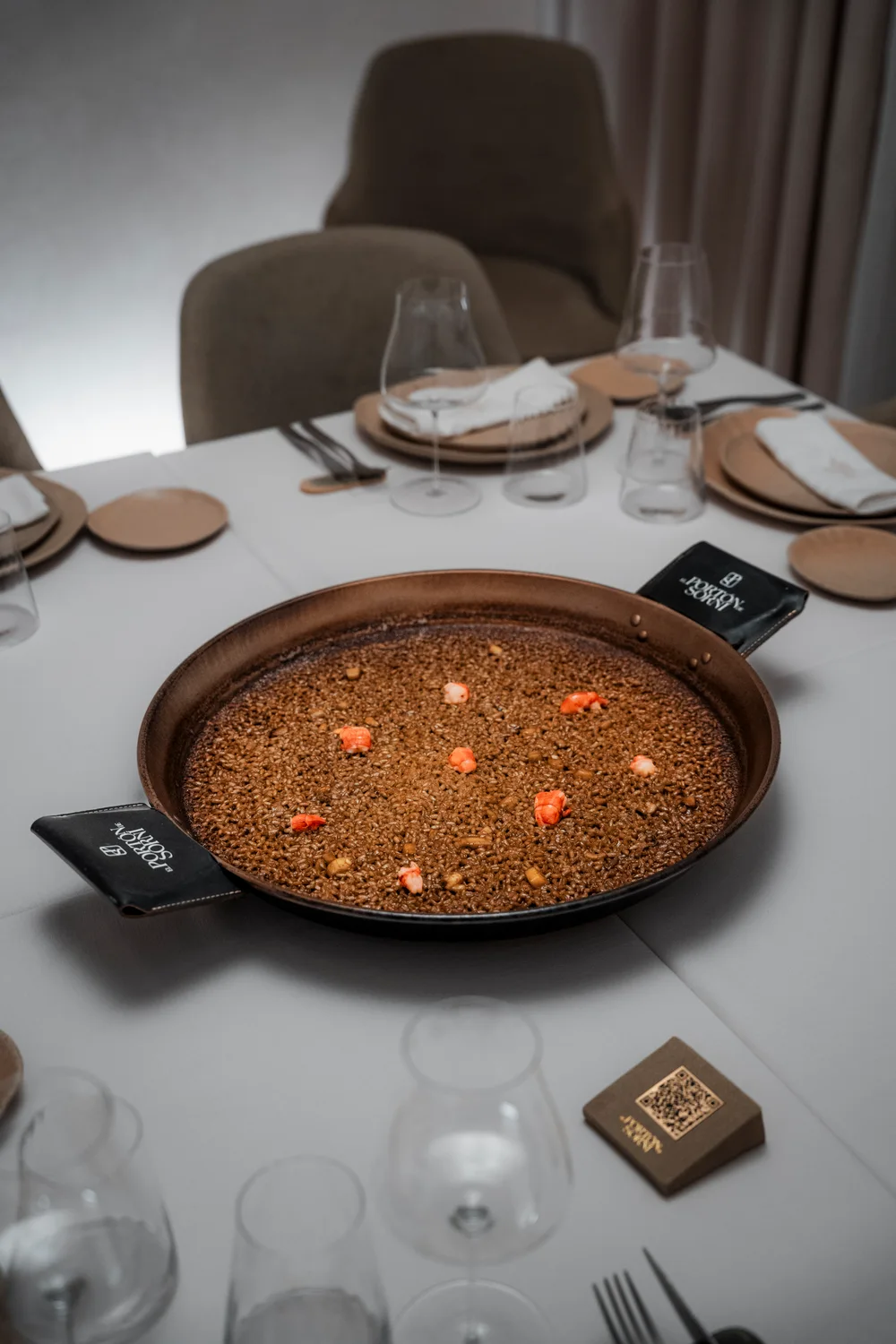 Paella de arroz seco servida sobre una mesa de El Portón de Sorní