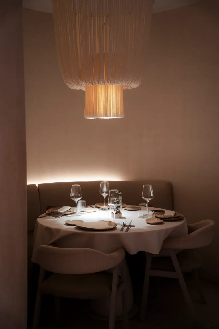 Mesa preparada junto a la pared e iluminación cálida en El Portón de Sorní