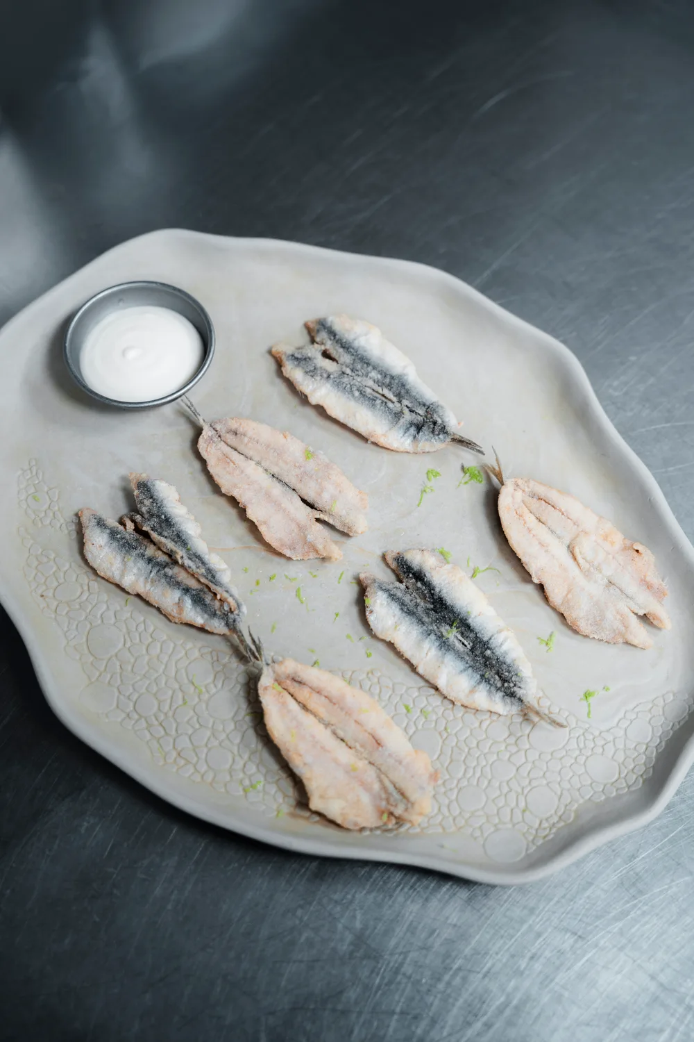 Filetes dispuestos sobre un plato con un pequeño recipiente de salsa
