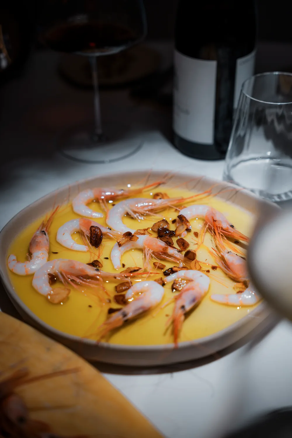 Plato con salsa anaranjada, piezas rosadas y blancas y acabado crujiente sobre la mesa